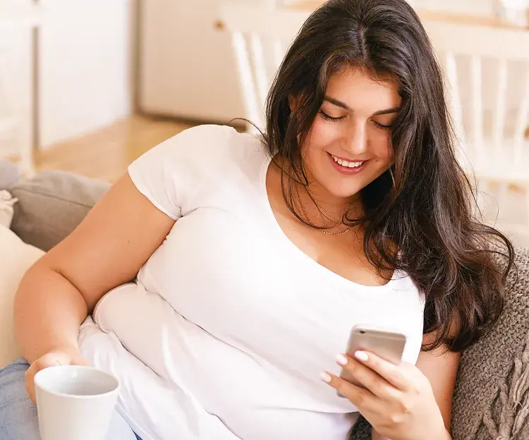 Frau auf dem Sofa mit Handy
